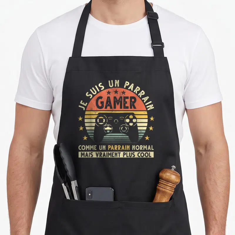 Tablier de cuisine noir avec illustration manette de jeu vidéo vintage et texte Je suis un parrain gamer comme un parrain normal mais vraiment plus cool