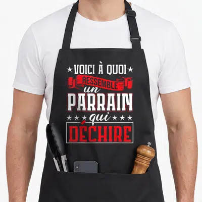 Tablier de cuisine noir avec inscription blanche et rouge voici à quoi ressemble un parrain qui déchire entouré d'étoiles.