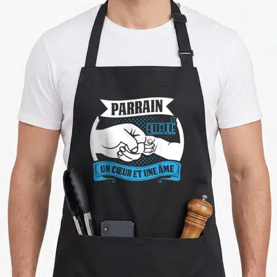 Tablier de cuisine noir avec illustration mains jointes et texte parrain et filleule un cœur et une âme en blanc et bleu.