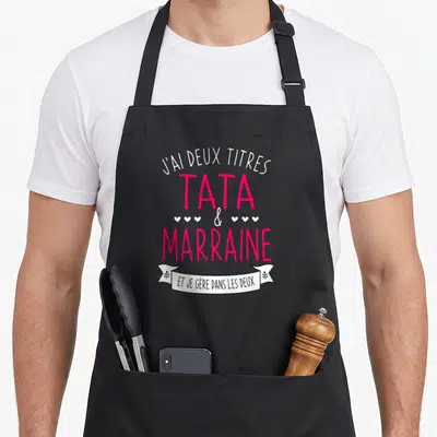 Tablier de cuisine noir avec inscription J'ai deux titres Tata et Marraine et je gère dans les deux en rose et blanc.