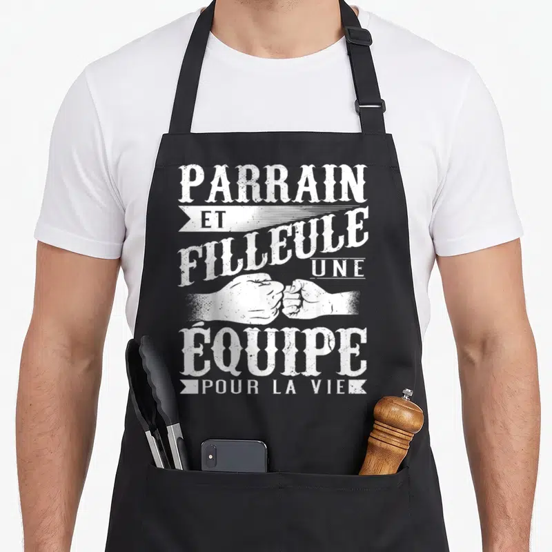 Tablier de cuisine noir avec inscription blanche parrain et filleule une équipe pour la vie et deux poings qui se touchent.