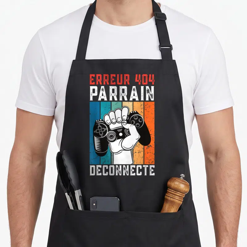 Tablier de cuisine noir avec illustration main tenant manette et texte Erreur 404 Parrain Déconnecté sur bandes colorées.