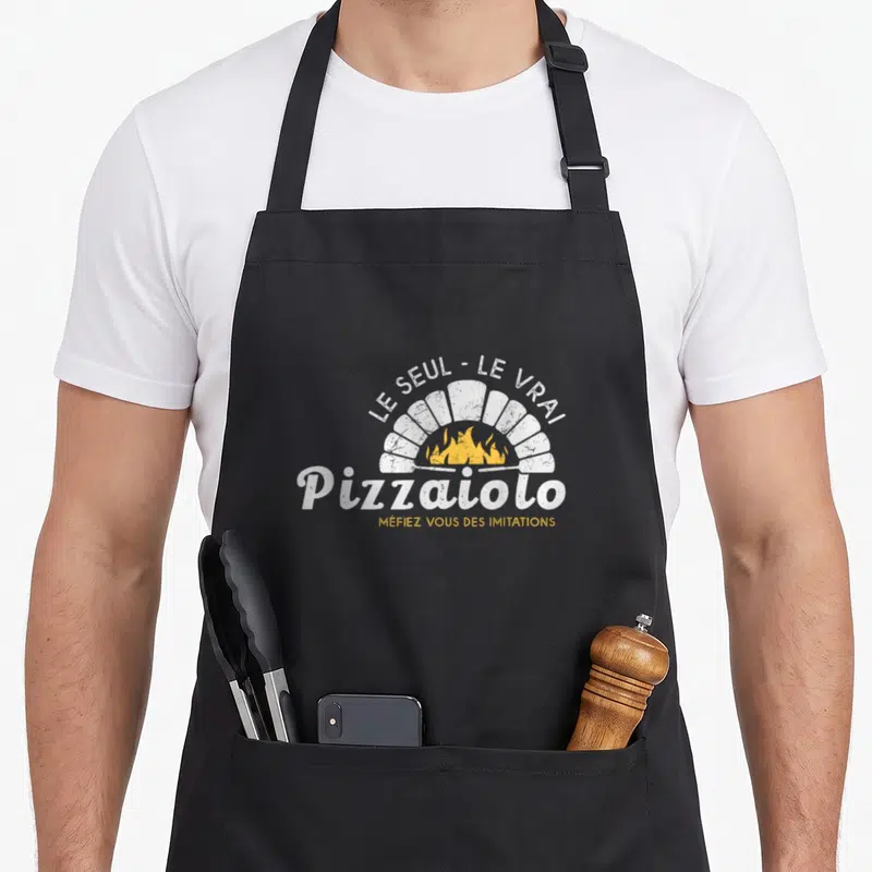 Tablier de cuisine noir avec logo blanc et jaune représentant un four à pizza et le texte Le Seul Le Vrai Pizzaiolo.