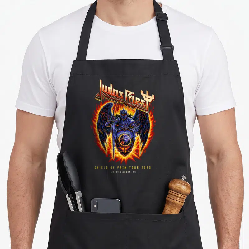 Tablier de cuisine noir avec illustration d'un chevalier ailé en armure bleue entouré de flammes et le texte Judas Priest Shield of Pain Tour 2025 Clisson.