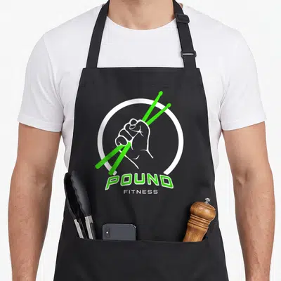 Tablier de cuisine noir avec illustration poing tenant baguettes vertes et logo Pound Fitness en blanc et vert.