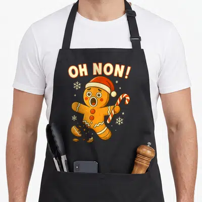 Tablier de cuisine noir avec bonhomme pain d'épices en panique tenant une canne à sucre et le texte Oh Non au-dessus.