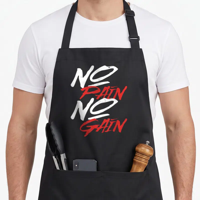 Tablier de cuisine noir avec l'inscription No Pain No Gain en typographie blanche et rouge stylisée.