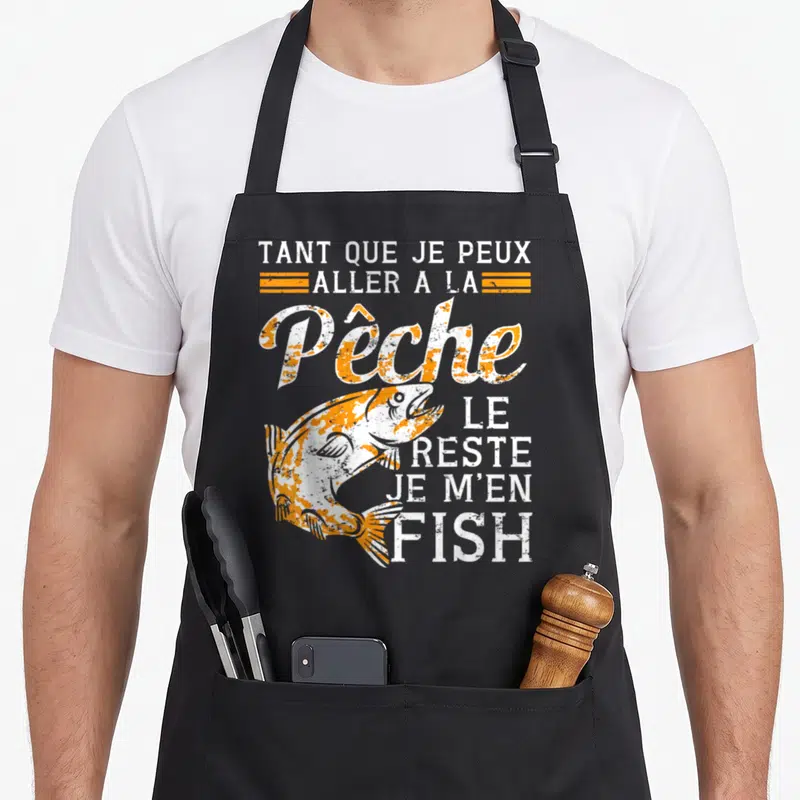 Tablier de cuisine noir avec un poisson sauteur orange et blanc et texte humoristique sur la pêche.