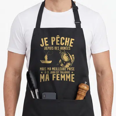 Tablier de cuisine noir avec inscription dorée Je pêche depuis des années ma femme et silhouette de pêcheur en bateau.