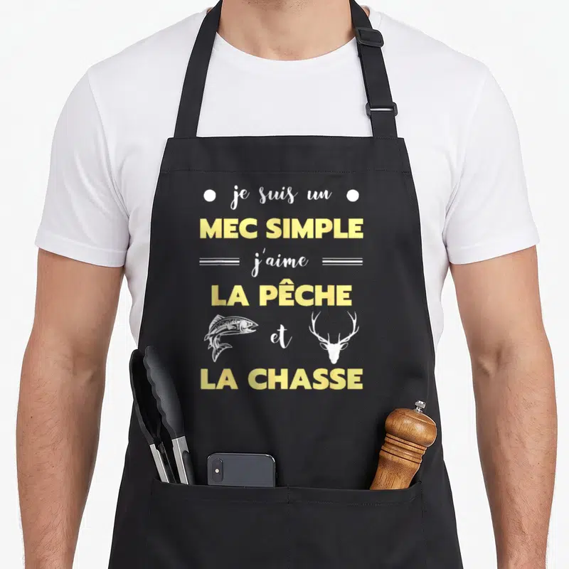 Tablier de cuisine noir avec inscription jaune et blanche mec simple j'aime la pêche et la chasse illustré d'un poisson et d'une tête de cerf.