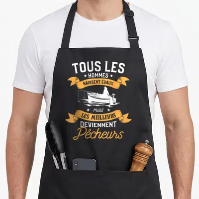 Tablier de cuisine noir avec inscription tous les hommes naissent égaux mais les meilleurs deviennent pêcheurs et silhouette de bateau.