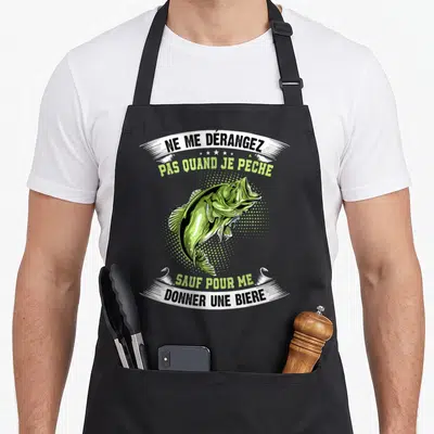 Tablier de cuisine noir avec illustration d'un bar vert et texte humoristique sur la pêche et la bière.