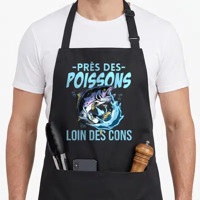 Tablier de cuisine noir avec un saumon sautant et le texte près des poissons loin des cons en bleu clair.