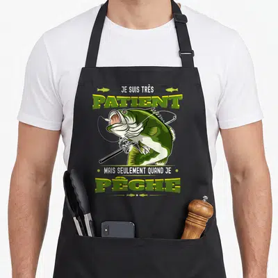 Tablier de cuisine noir avec un brochet illustré tenant une canne à pêche et le texte Je suis très patient mais seulement quand je pêche