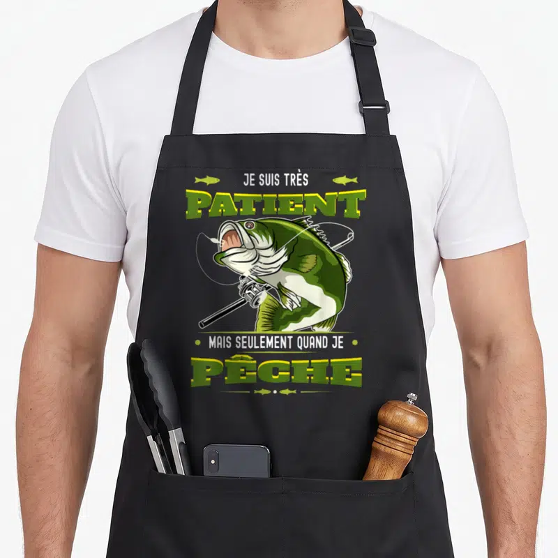 Tablier de cuisine noir avec un brochet illustré tenant une canne à pêche et le texte Je suis très patient mais seulement quand je pêche