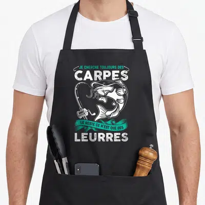 Tablier de cuisine noir avec illustration blanche d'une carpe, canne à pêche et texte humoristique sur le thème de la pêche.