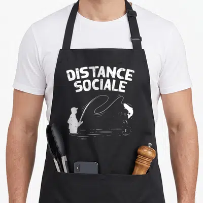Tablier de cuisine noir avec une illustration blanche d'un pêcheur et du texte Distance Sociale.