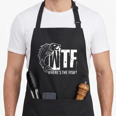 Tablier de cuisine noir avec l'inscription WTF Where's the Fish et un dessin de poisson stylisé en blanc.