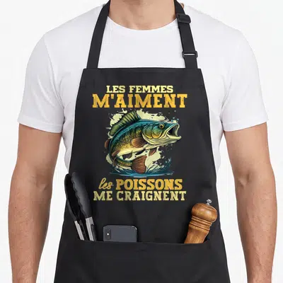 Tablier de cuisine noir avec illustration colorée d'un poisson sautant et texte jaune Les Femmes M'Aiment Les Poissons Me Craignent.