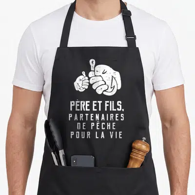 Tablier de cuisine noir avec illustration de deux poings et le texte blanc Père et fils partenaires de pêche pour la vie.