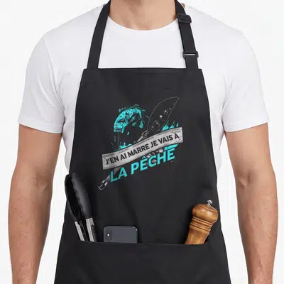 Tablier de cuisine noir avec illustration d'un poisson turquoise et une canne à pêche grise sur fond uni.