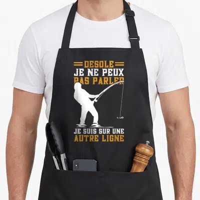Tablier de cuisine noir avec silhouette blanche d'un pêcheur et texte orange et blanc.