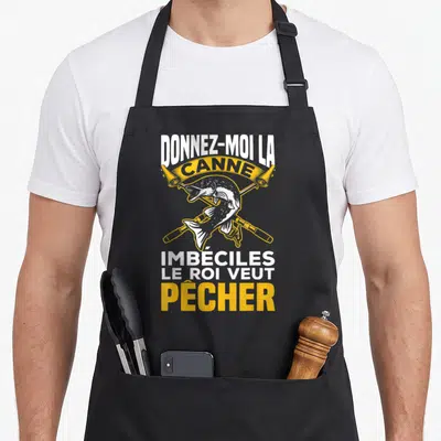 Tablier de cuisine noir avec une illustration de poisson et deux cannes à pêche croisées en jaune et blanc.