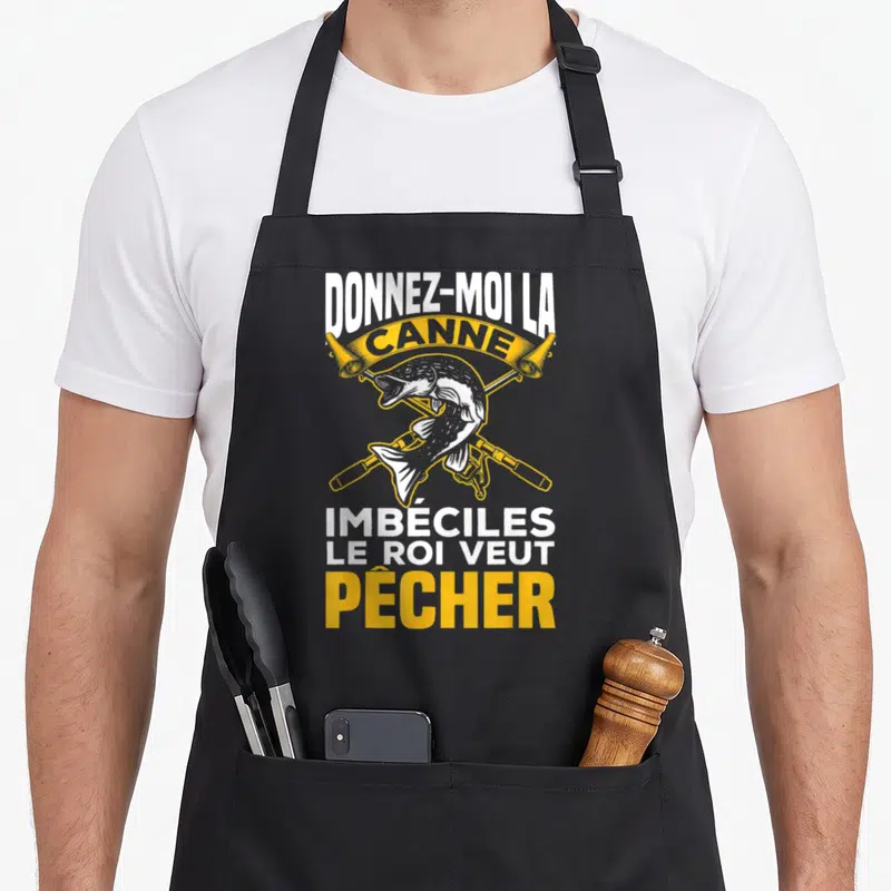 Tablier de cuisine noir avec une illustration de poisson et deux cannes à pêche croisées en jaune et blanc.