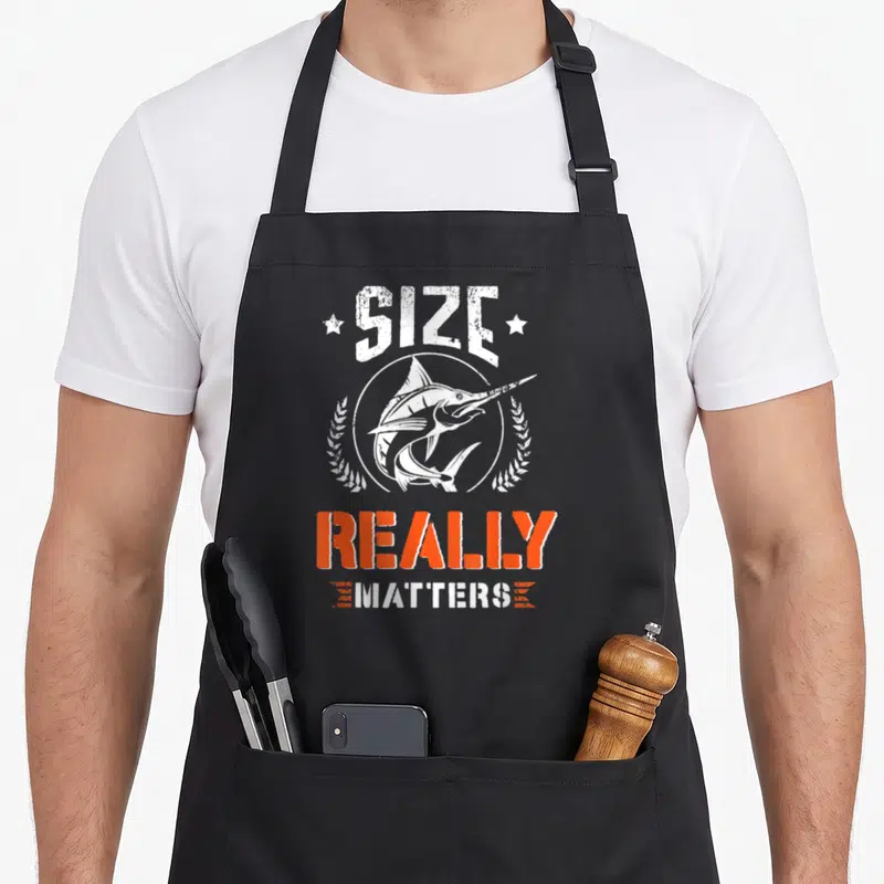 Tablier de cuisine noir avec illustration d'espadon et texte Size Really Matters en blanc et orange.