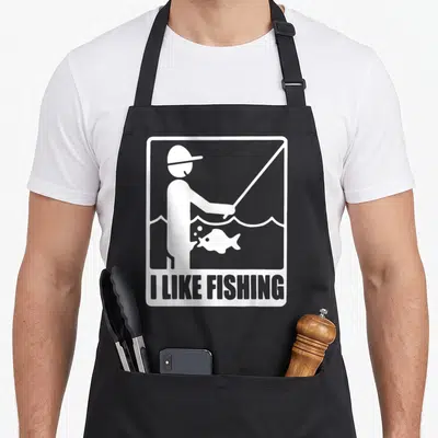 Tablier de cuisine noir avec une illustration blanche d'un pêcheur et du texte I LIKE FISHING en bas.