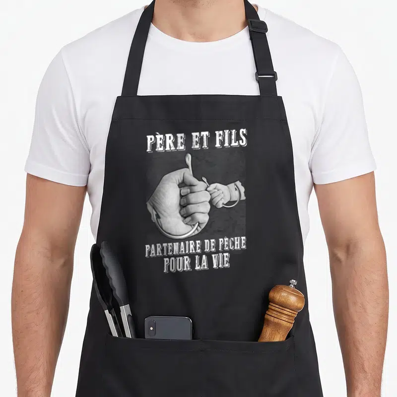 Tablier de cuisine noir avec une illustration en noir et blanc d'une main d'adulte et d'un enfant tenant un hameçon ensemble.