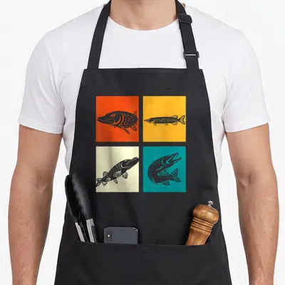 Tablier de cuisine noir avec quatre illustrations de brochets sur carrés colorés orange, jaune, crème et turquoise.