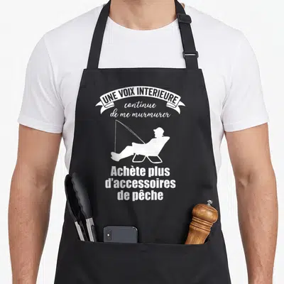 Tablier de cuisine noir avec une silhouette blanche d'un pecheur assis et le texte Achète plus d'accessoires de pêche.