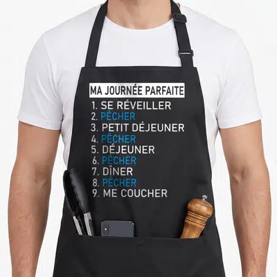 Tablier de cuisine noir avec la liste Ma Journée Parfaite et le verbe pêcher répété en bleu vif sur fond blanc.