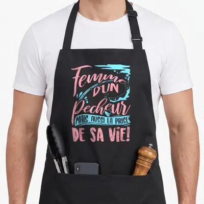 Tablier de cuisine noir avec une inscription rose et bleue célébrant les femmes de pêcheurs et leur passion.