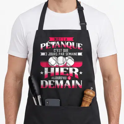 Tablier de cuisine noir avec inscription rose et blanche sur la pétanque et trois boules dessinées au centre.