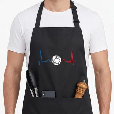 Tablier de cuisine noir avec un électrocardiogramme bleu et rouge entourant une boccia blanche stylisée au centre du torse.