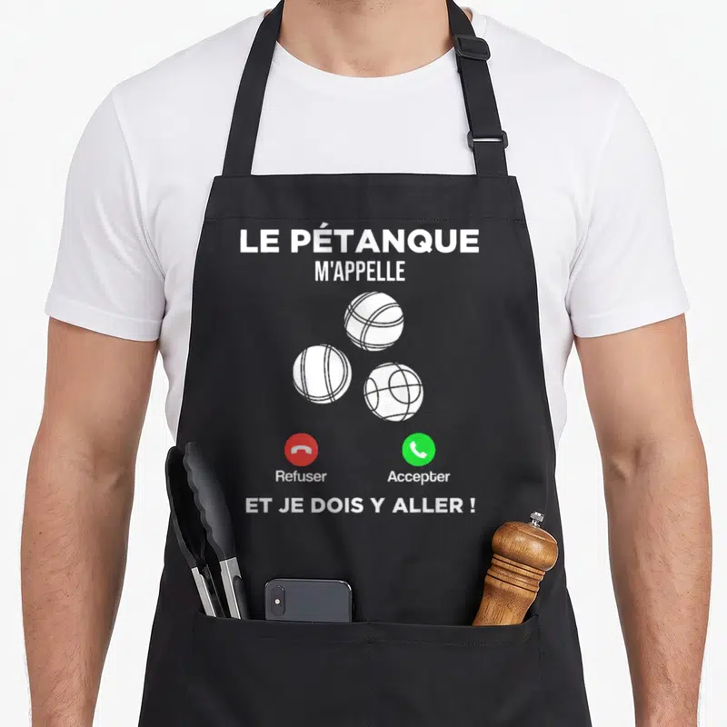 Tablier de cuisine noir avec trois boules blanches stylisées et texte blanc humoristique sur la pétanque.