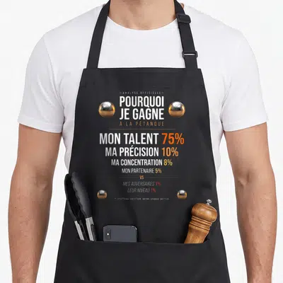 Tablier de cuisine noir avec analyse pourquoi je gagne à la pétanque et boules métalliques dorées et argentées.