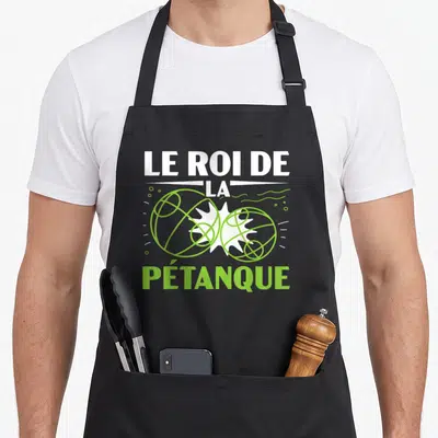 Tablier de cuisine noir avec inscription Le Roi de la Pétanque et illustration de deux boules de boccia vertes se touchant.