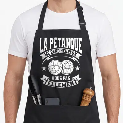 Tablier de cuisine noir avec l'inscription La Pétanque Me Rend Heureux et deux boules blanches stylisées.