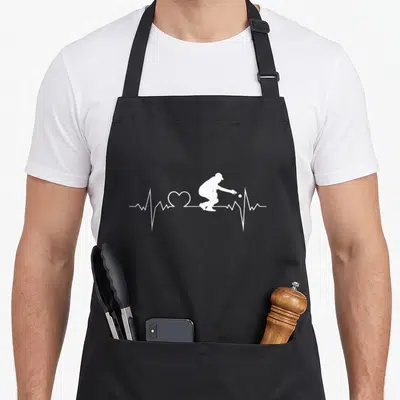 Tablier de cuisine noir avec silhouette blanche d'un homme lançant une boule sur une ligne de rythme cardiaque incluant un cœur.