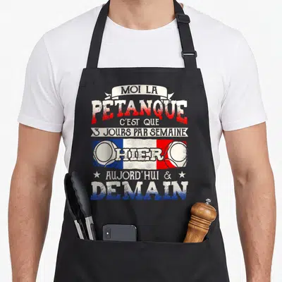 Tablier de cuisine noir avec inscription humoristique sur la passion de pétanque et drapeau français stylisé.
