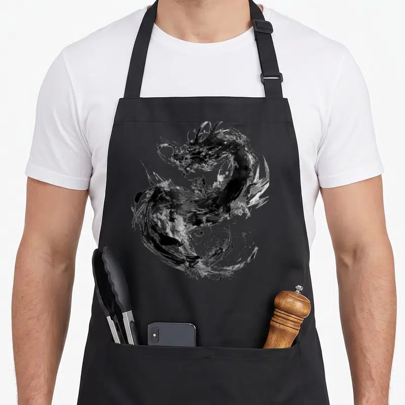 Tablier de cuisine noir avec un dragon dessiné en art abstrait aux traits de peinture noire et blanche.