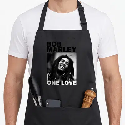 Tablier de cuisine noir avec portrait noir et blanc de Bob Marley et texte One Love en bas.