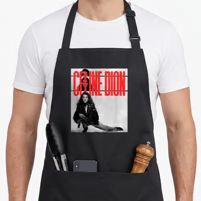 Tablier de cuisine noir avec une illustration monochrome d'une femme en veste en cuir et le texte Celine Dion en rouge vif superposé.