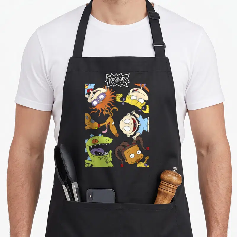 Tablier de cuisine noir avec une illustration colorée montrant six personnages vus d'en haut et un logo stylisé en haut.