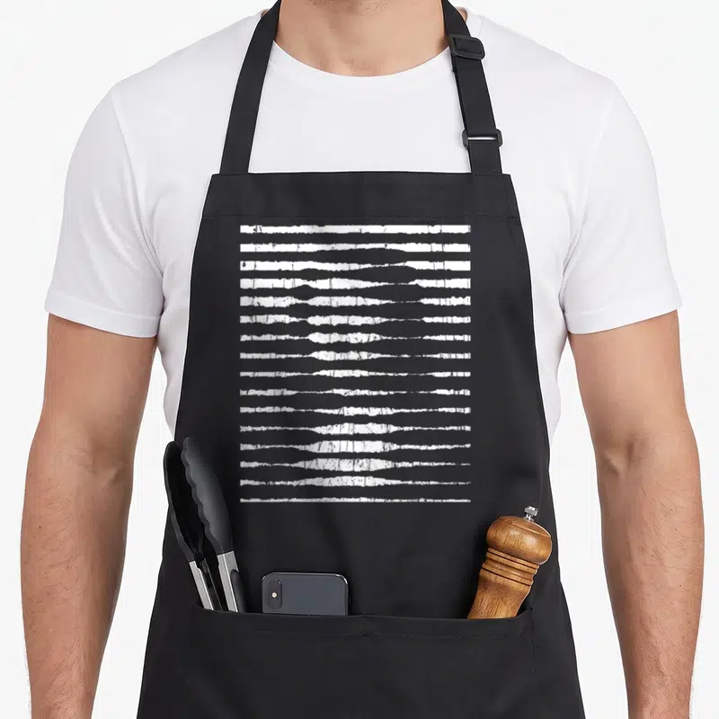 Tablier de cuisine noir avec motif bandes blanches horizontales formant un portrait optical Mona Lisa en style art da Vinci.