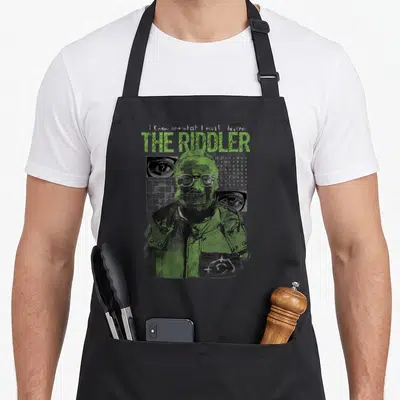 Tablier de cuisine noir avec illustration verte du Riddler, texte stylisé et détails graphiques sombres sur le devant.