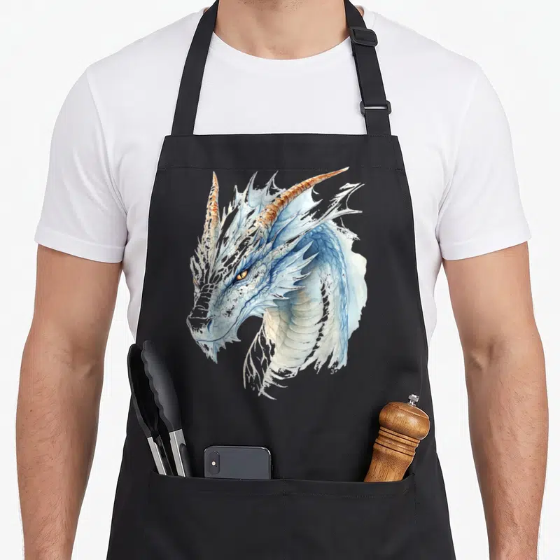 Tablier de cuisine noir avec tête de dragon blanc aux écailles bleutées et cornes dorées.